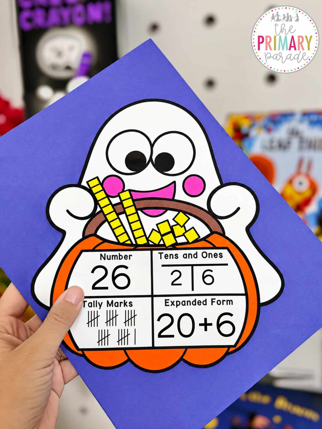 Halloween math craft showing a ghost holding a pumpkin basket with base ten blocks for kindergarten and first grade place value and number sense