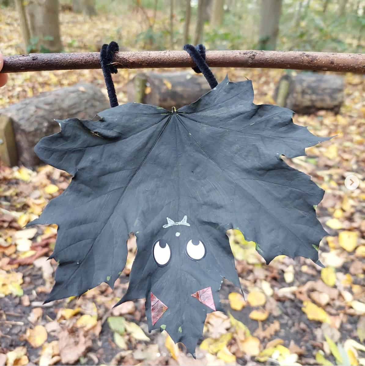 Painted fall leaf bat hanging from a branch